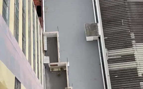 Dois profissionais da Prime Color trabalhando juntos no alto de um edifício