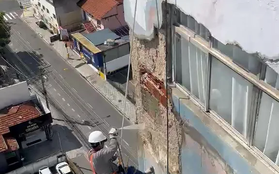 Profissional da Prime Color descendo por corda para trabalhar na fachada de um edifício